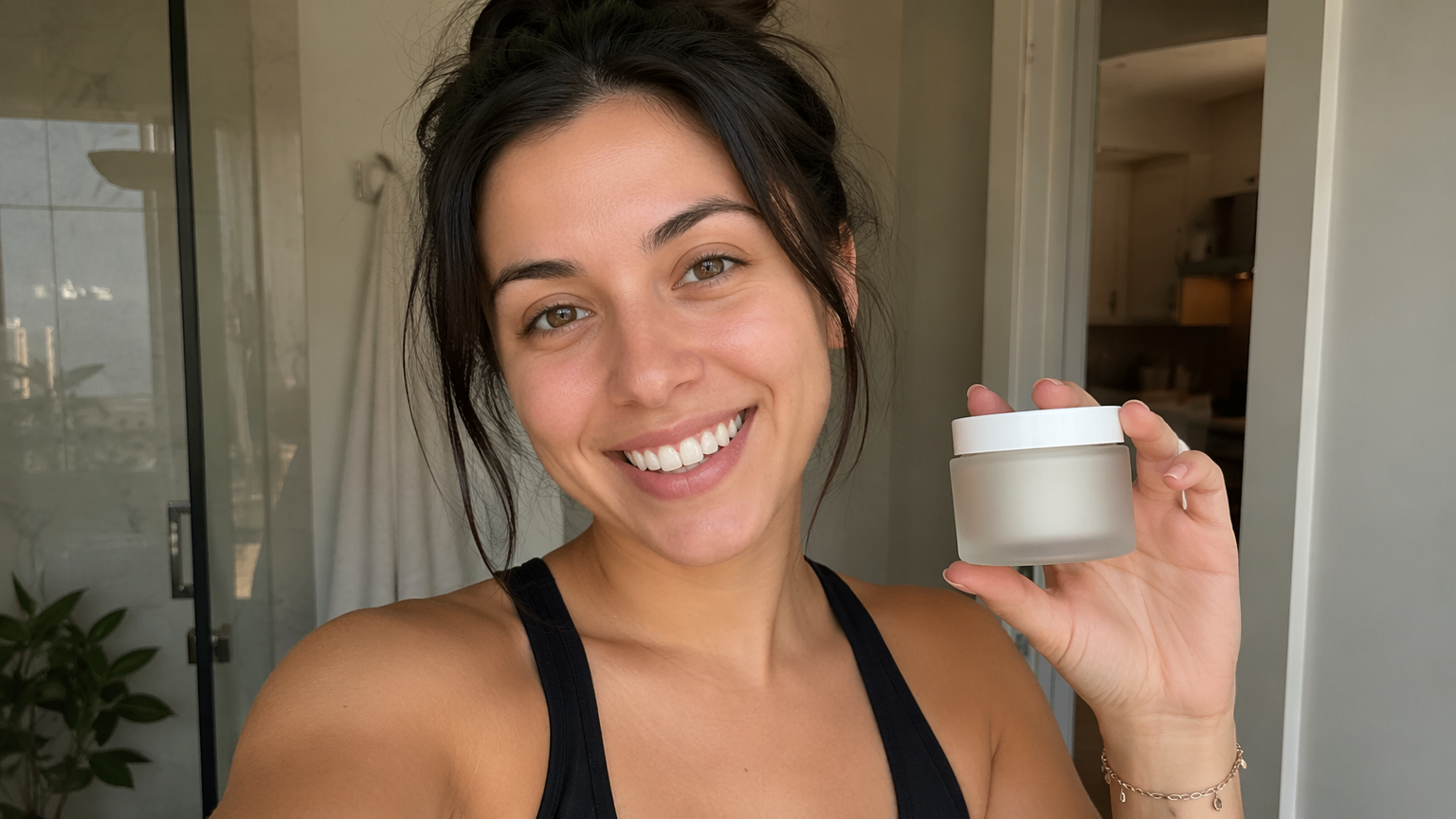 Original young woman creator holding an unbranded cosmetic jar to camera in a bright home
