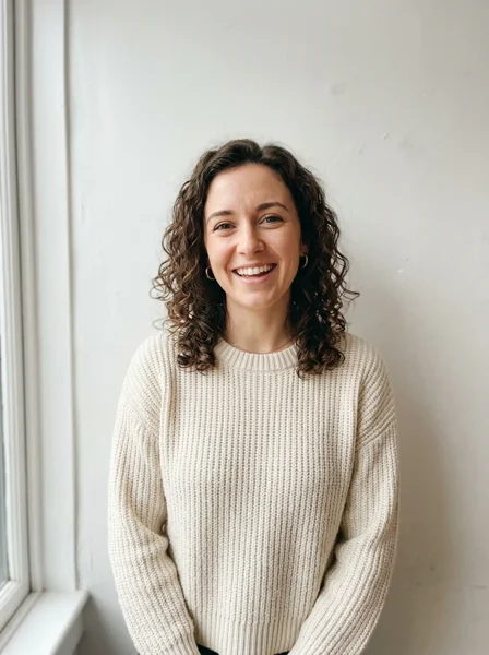 The input photo: a woman with curly dark hair in a cream sweater